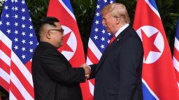 North Korea's leader Kim Jong Un (L) shakes hands with US President Donald Trump (R) at the start of their historic US-North Korea summit, at the Capella Hotel on Sentosa island in Singapore on June 12, 2018.