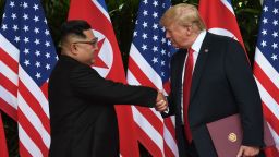 North Korea's leader Kim Jong Un (L) shakes hands with US President Donald Trump (R) after taking part in a signing ceremony at the end of their historic US-North Korea summit, at the Capella Hotel on Sentosa island in Singapore on June 12, 2018. 