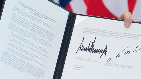 US President Donald Trump holds up a document signed by him and North Korea's leader Kim Jong Un following a signing ceremony during their historic US-North Korea summit, at the Capella Hotel on Sentosa island in Singapore on June 12, 2018. - Donald Trump and Kim Jong Un became on June 12 the first sitting US and North Korean leaders to meet, shake hands and negotiate to end a decades-old nuclear stand-off. (Photo by SAUL LOEB / AFP)        (Photo credit should read SAUL LOEB/AFP/Getty Images)