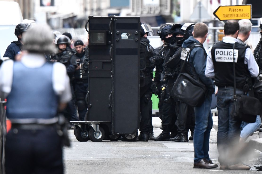 Officers from the Research and Intervention Brigade prepare a shield near the  scene Tuesday in Paris. 