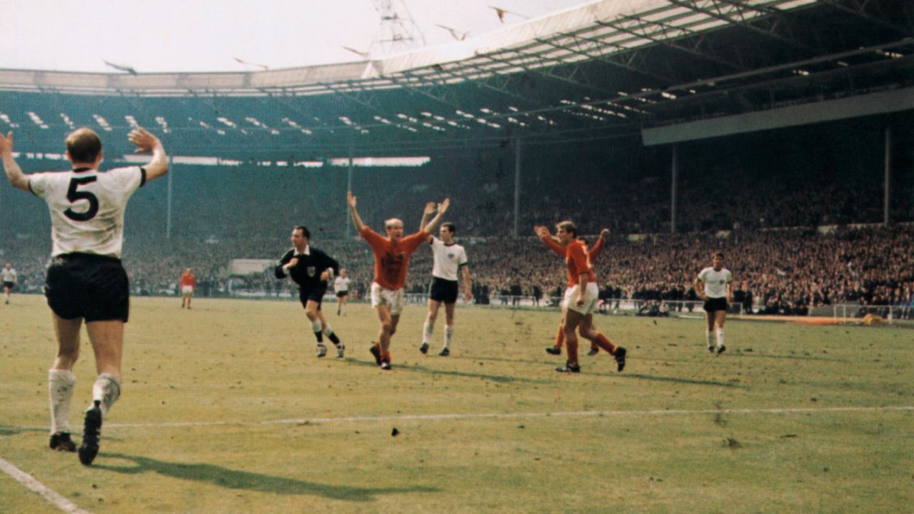 Bobby Charlton (centre) holds his hands up as West German players protest after Geoff Hurst scores the controversial third goal during the World Cup final at Wembley Stadium.