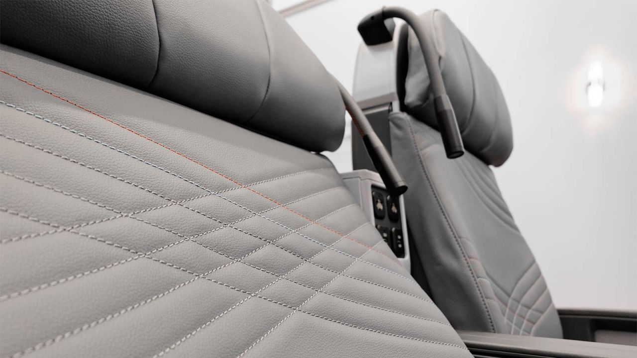 <strong>Lie back in leather:</strong> The seats are stitched leather, and each includes a reading light and three power ports (two USB, one universal A/C).