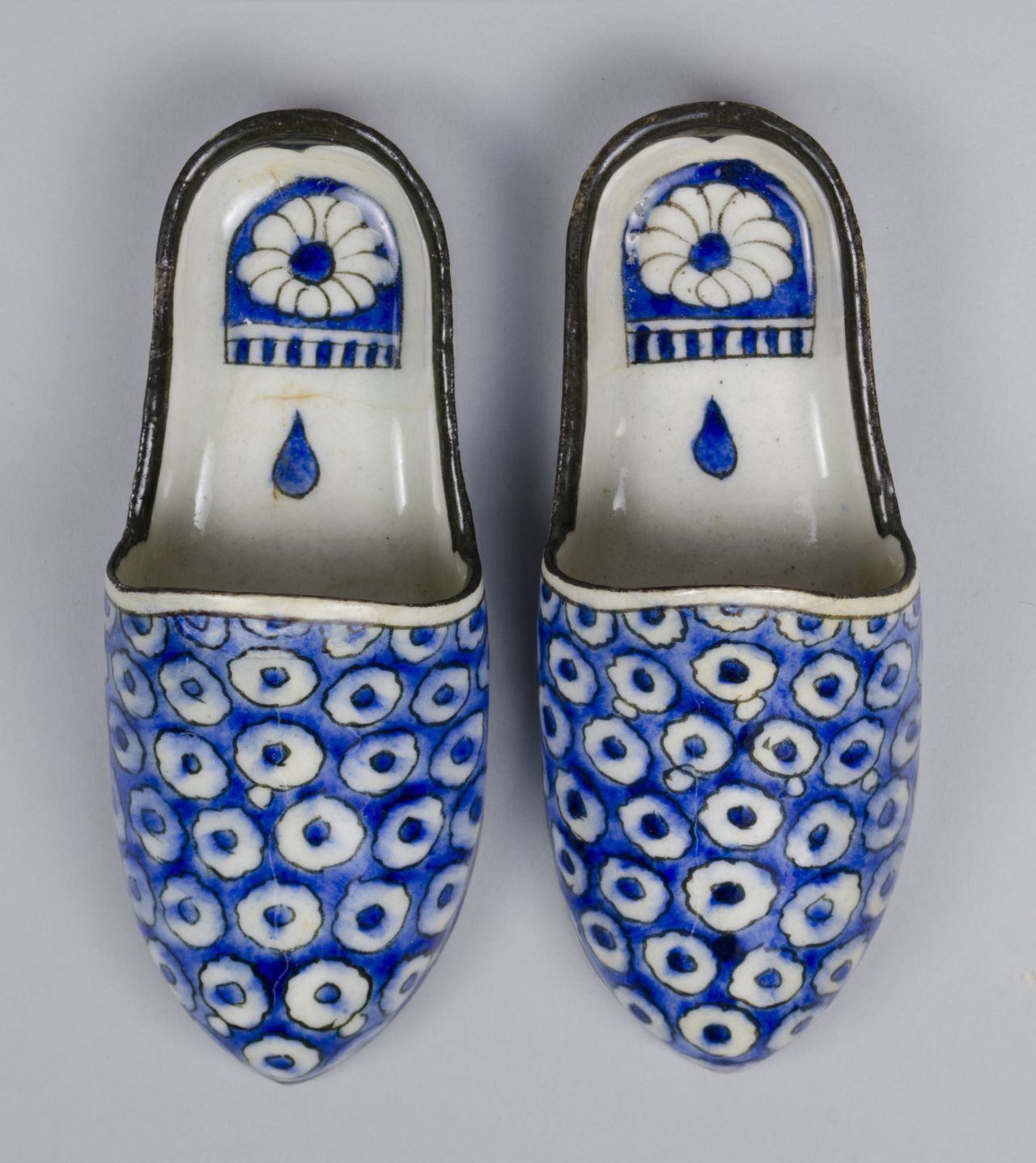 A pair of Chinese-made porcelain slippers from the 18th century. While serving as objets d'art, the shoes would have been used in semi-public bathhouses.