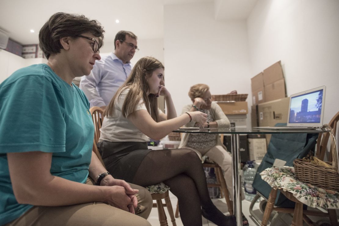 The Alves family, along with a former Grenfell neighbor, watch a documentary about the fire, in the kitchen of the their temporary home in Kensington.