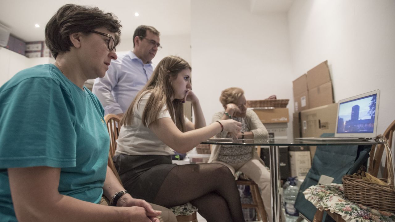 The Alves family, along with a former Grenfell neighbor, watch a documentary about the fire, in the kitchen of the their temporary home in Kensington.