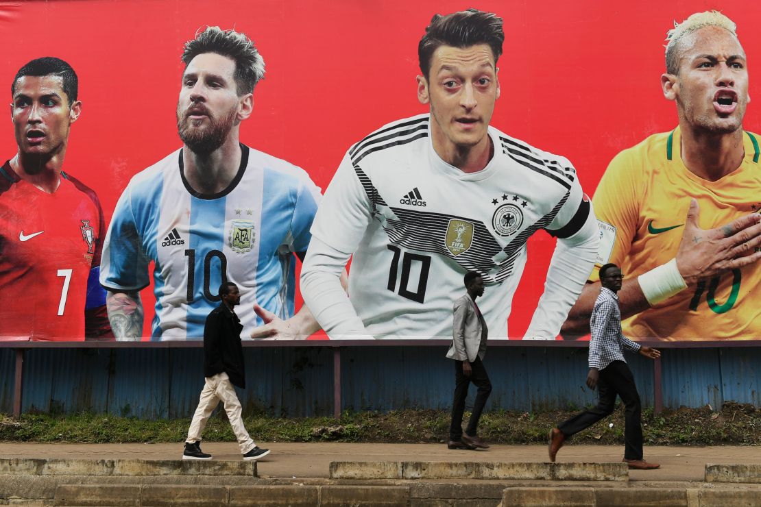 People walk past a football billboard displaying Portugal's forward Cristiano Ronaldo, Argentina's forward Lionel Messi, Germany's midfielder Mesut Ozil and Brazil's striker Neymar in Nairobi, ahead of the Russia 2018 World Cup.