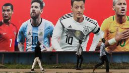 People walk past a football billboard displaying (From L) Portugal's forward Cristiano Ronaldo, Argentina's forward Lionel Messi, Germany's midfielder Mesut Ozil and Brazil's striker Neymar on June 9, 2018 in Nairobi, ahead of the Russia 2018 World Cup. (Photo by SIMON MAINA / AFP)        (Photo credit should read SIMON MAINA/AFP/Getty Images)