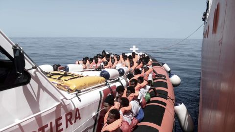 Migrants are transferred from the Aquarius to Italian Coast Guard vessels in the Mediterranean Sea.