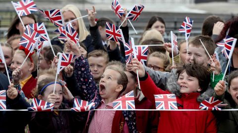 Schoolchildren near Runcorn Station wait to see the monarch and new royal arrive in the Cheshire town to open a new toll bridge nearby.