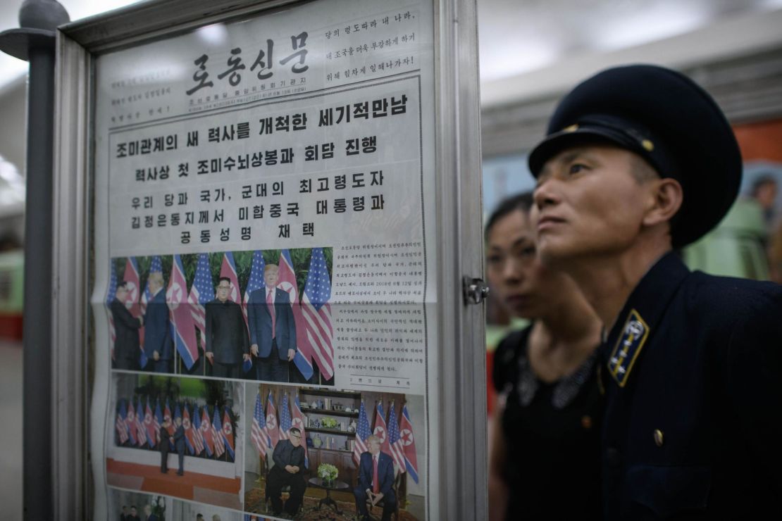 A conductor reads the latest edition of the Rodong Sinmun newspaper showing images of North Korean leader Kim Jong Un meeting with US president Donald Trump during their summit in Singapore, at a news stand on a subway platform of the Pyongyang metro on June 13, 2018. 