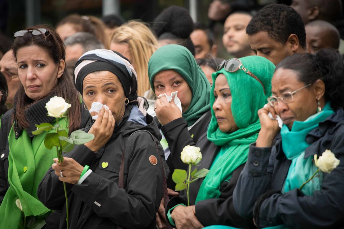 Families of victims of the Grenfell Tower disaster attend a service at the base of the burned-out apartment block on  Thursday.