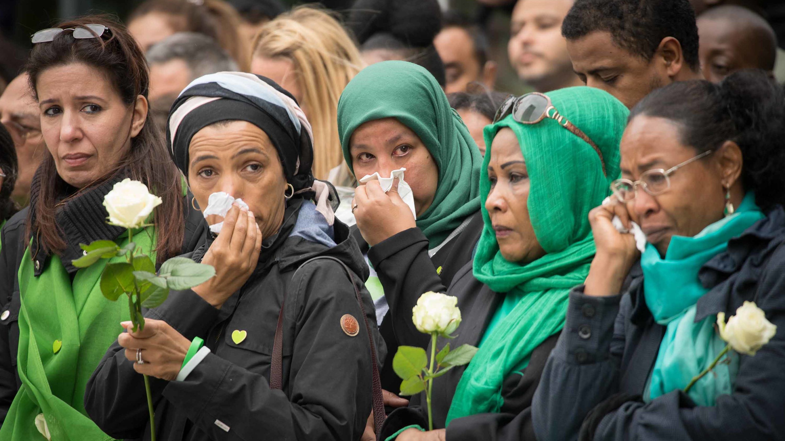 Families of victims of the Grenfell Tower disaster attend a service at the base of the burned-out apartment block on  Thursday.