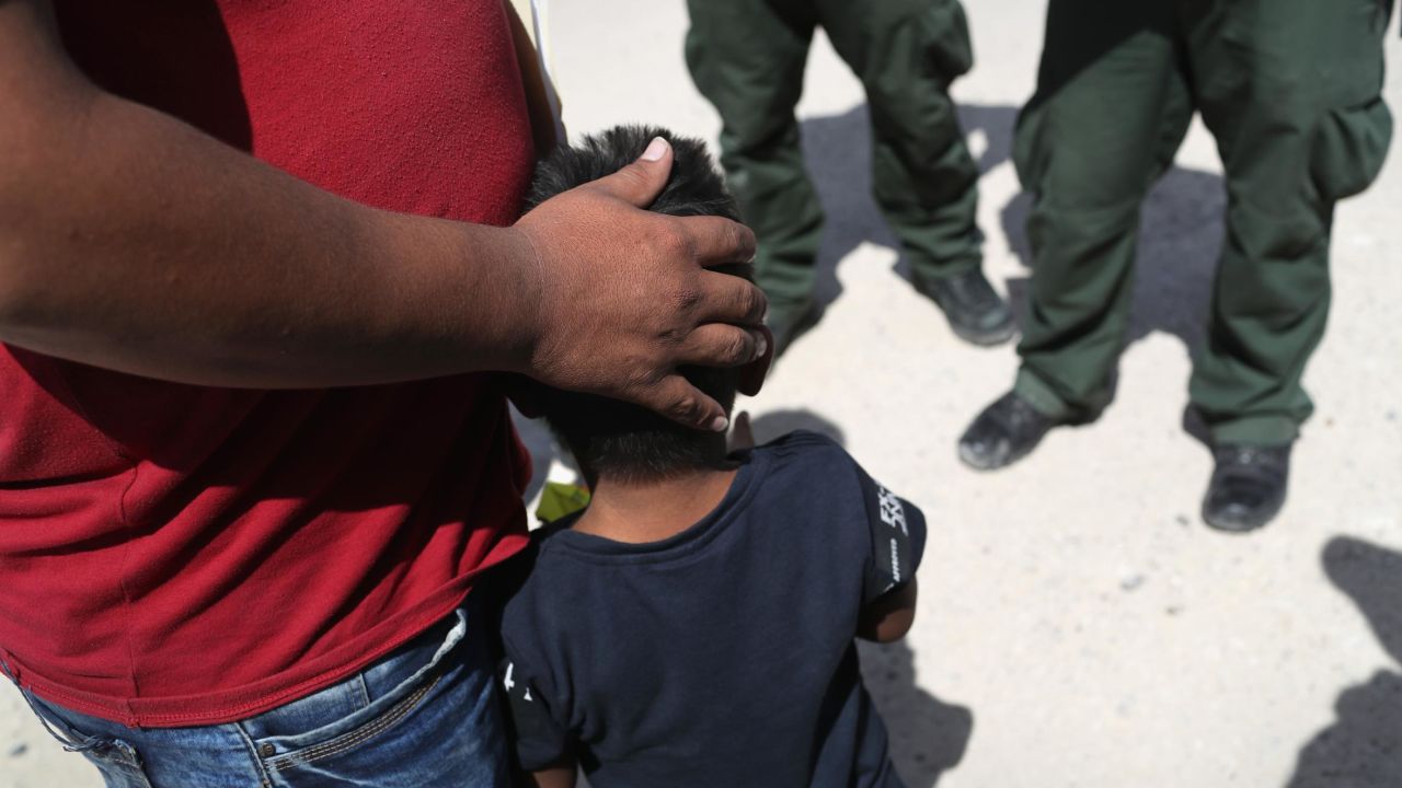 US Border Patrol agents take a father and son from Honduras into custody near the US-Mexico border in June 2018.