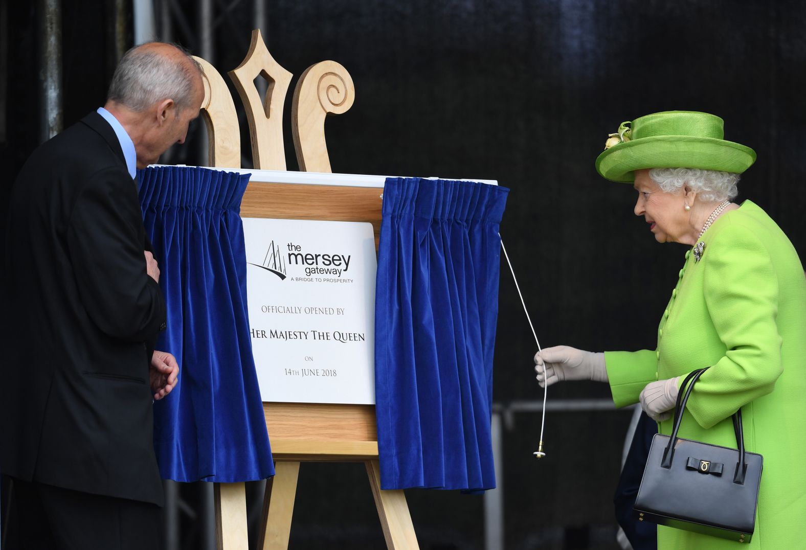Queen Elizabeth pulls the curtain to officially open the new Mersey Gateway Bridge in the town of Widnes in Halton, England.