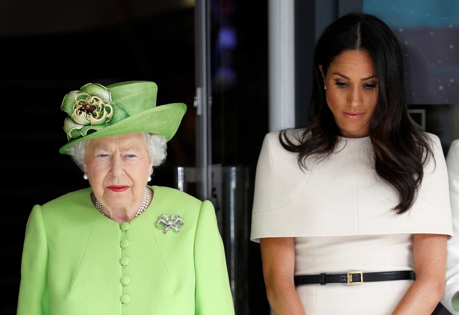 During their visit to Chester, Queen Elizabeth and Meghan observe a moment of silence in memory of the victims of the Grenfell Tower fire disaster.