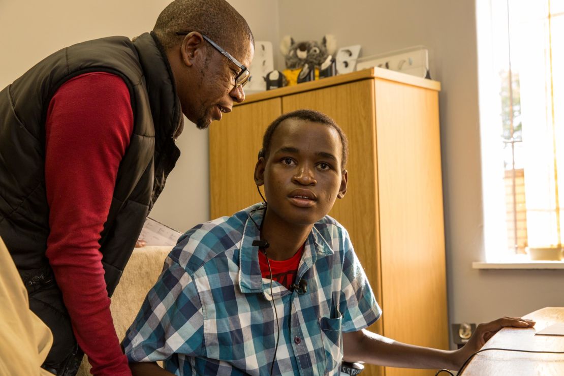 Mzwandile Khumalo, an MSF field coordinator, tests Khumbulani Shandu's new cochlear implant.