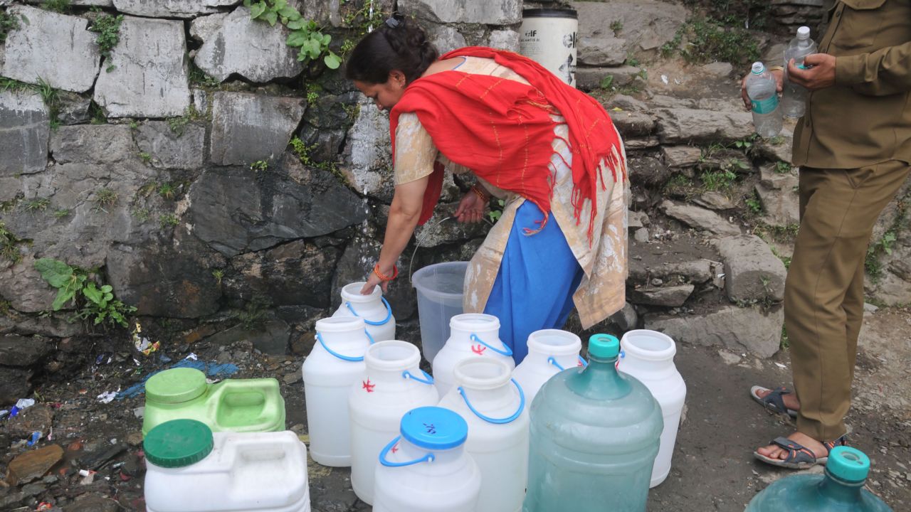 Indian residents wait to collect drinking water in Shimla as the city faces water shortage.