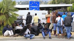 Migrants wait at the border between Italy and France in the city of Ventimiglia on June, 12, 2015. The Schengen open borders accord means migrants landing in Italy can usually easily travel through neighbouring France, Austria, Switzerland and Slovenia as they seek to make it to Britain, Germany and Scandinavia, but the G7 suspension of Schengen and a growing number of spot checks on buses and trains has made that harder, increasing the pressure on Italy, where reception facilities are at breaking point with some 76,000 people being accommodated nationwide. AFP PHOTO / JEAN-CHRISTOPHE MAGNENET        (Photo credit should read JEAN-CHRISTOPHE MAGNENET/AFP/Getty Images)