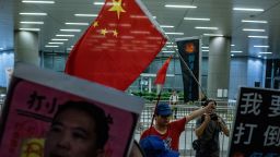 A Pro-Beijing protester (back centre) holds a Chinese flag during the Anti-Guangzhou-Shenzhen-Hong Kong Express Rail Link (Co-location) Bill rally outside the Legco complex in Hong Kong on June 14, 2018. - The 84.4 billion HKD (10.7 billion USD) high-speed rail link is one of a number of cross-border mega infrastructure projects which have increased concern that Hong Kong is being swallowed up by the mainland. (Photo by Philip FONG / AFP)        (Photo credit should read PHILIP FONG/AFP/Getty Images)