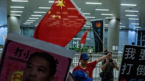 A Pro-Beijing protester (back centre) holds a Chinese flag during the anti-rail link rally outside the Legco complex in Hong Kong on June 14.