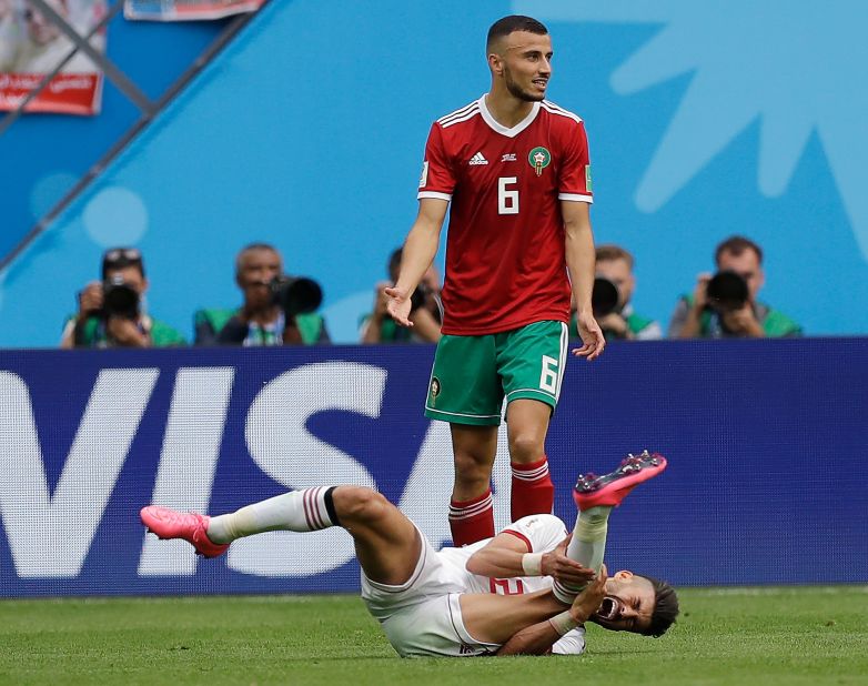 Iran's Alireza Jahanbakhsh grimaces in pain in front of Morocco's Romain Saiss.