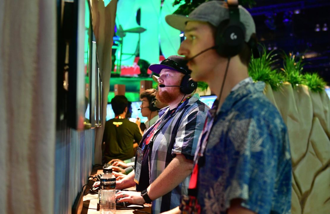 Gamers play "Fortnite" on PS4 consoles at E3 2018 in Los Angeles, California.