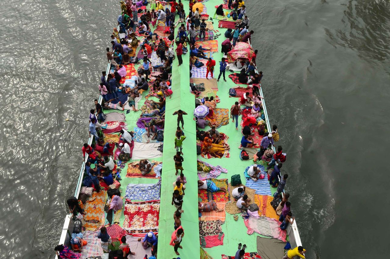 People travel on a ferry along the Buriganga River, on the outskirts of Dhaka, Bangladesh, to be with their families for Eid.