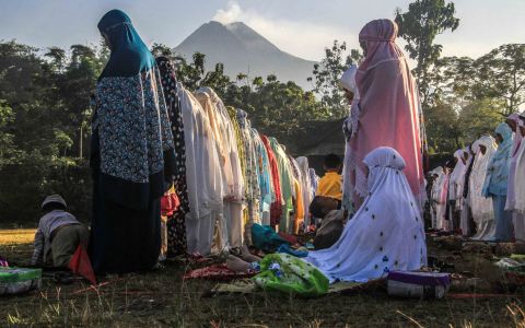 With Mount Merapi in the background, women perform Eid prayers in Yogyakarta, Indonesia.