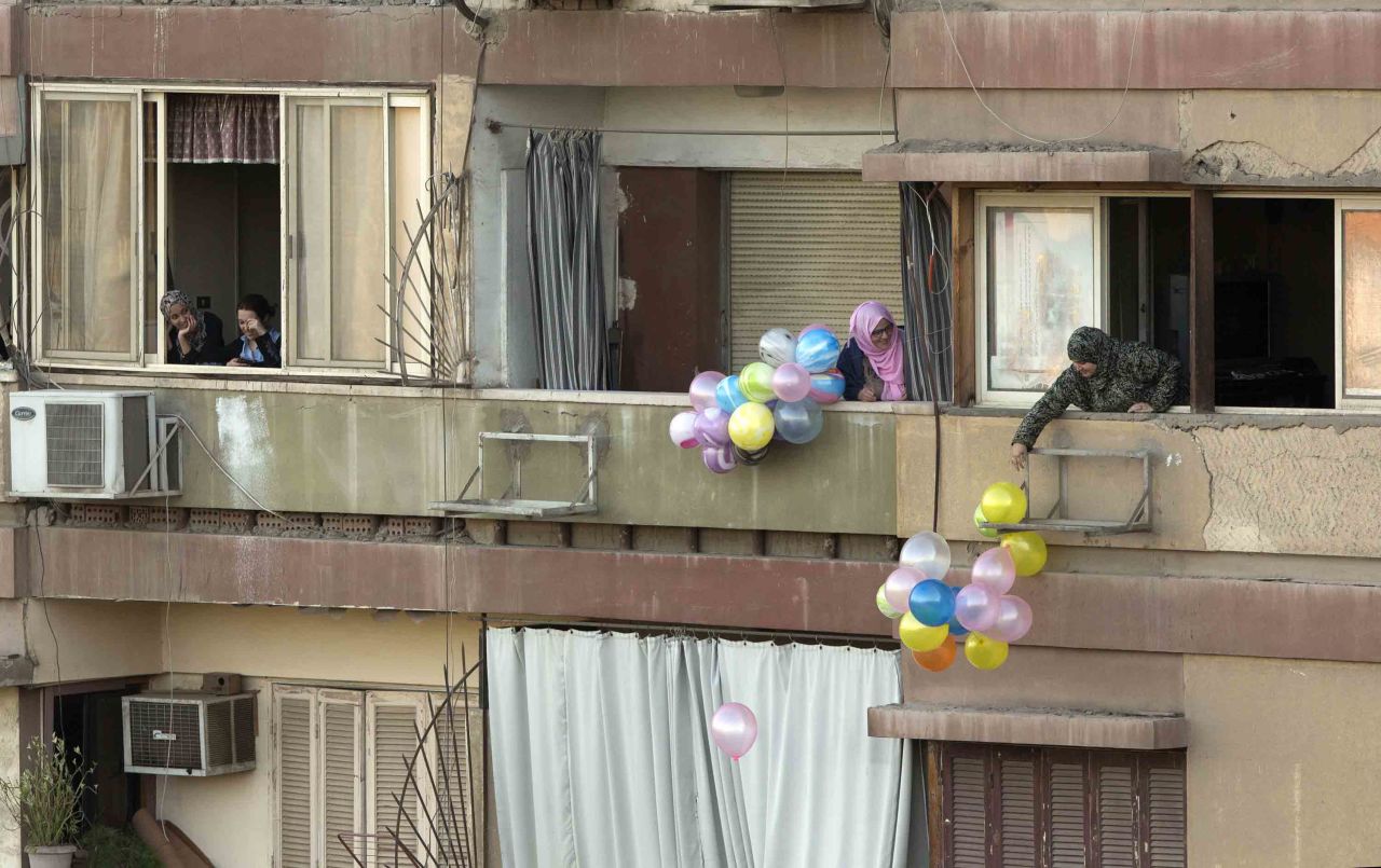 People throw balloons to passers-by in Cairo.
