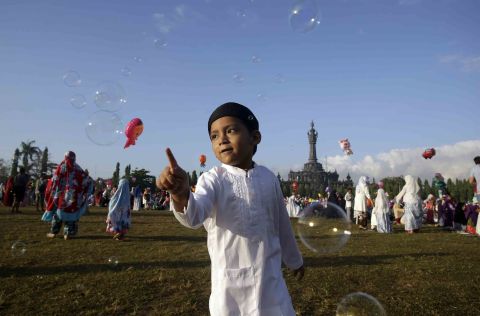 A boy plays with bubbles during Eid al-Fitr prayers in Bali, Indonesia.