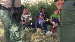 Dalila Suyapa and her son Cesar (center) take a break from the sun after Border Patrol agents took them in custody in Mission, Texas on June 16, 2018.