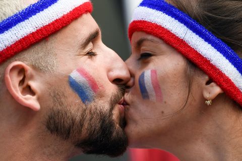 Fans of France share a kiss before the team's opening match with Australia on June 16.