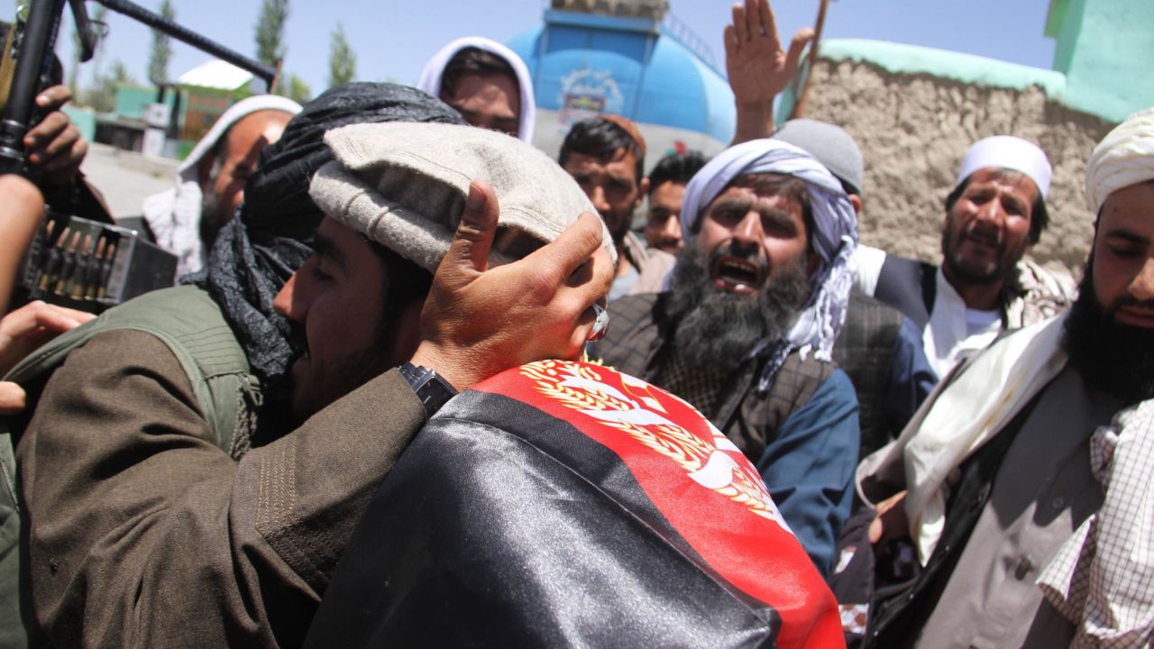 Purported Taliban militants and Afghans embrace Saturday in Ghazni during a three-day truce for Eid.