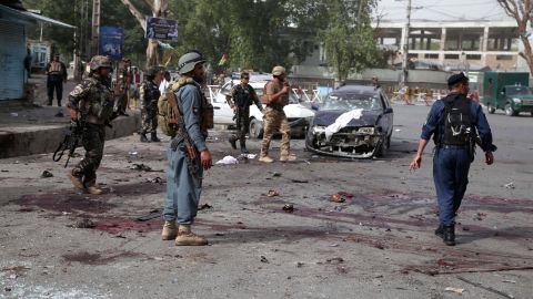 Afghan security officials inspect the scene of Sunday's suicide bombing near a meeting between the Nangarhar governor and Taliban militants. 
