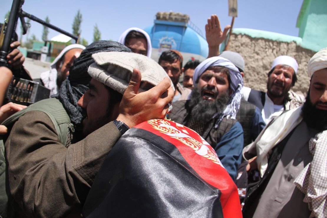 Purported Taliban militants and Afghans embrace Saturday in Ghazni during a three-day truce for Eid.