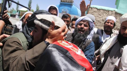 Purported Taliban militants and Afghans embrace Saturday in Ghazni during a three-day truce for Eid.