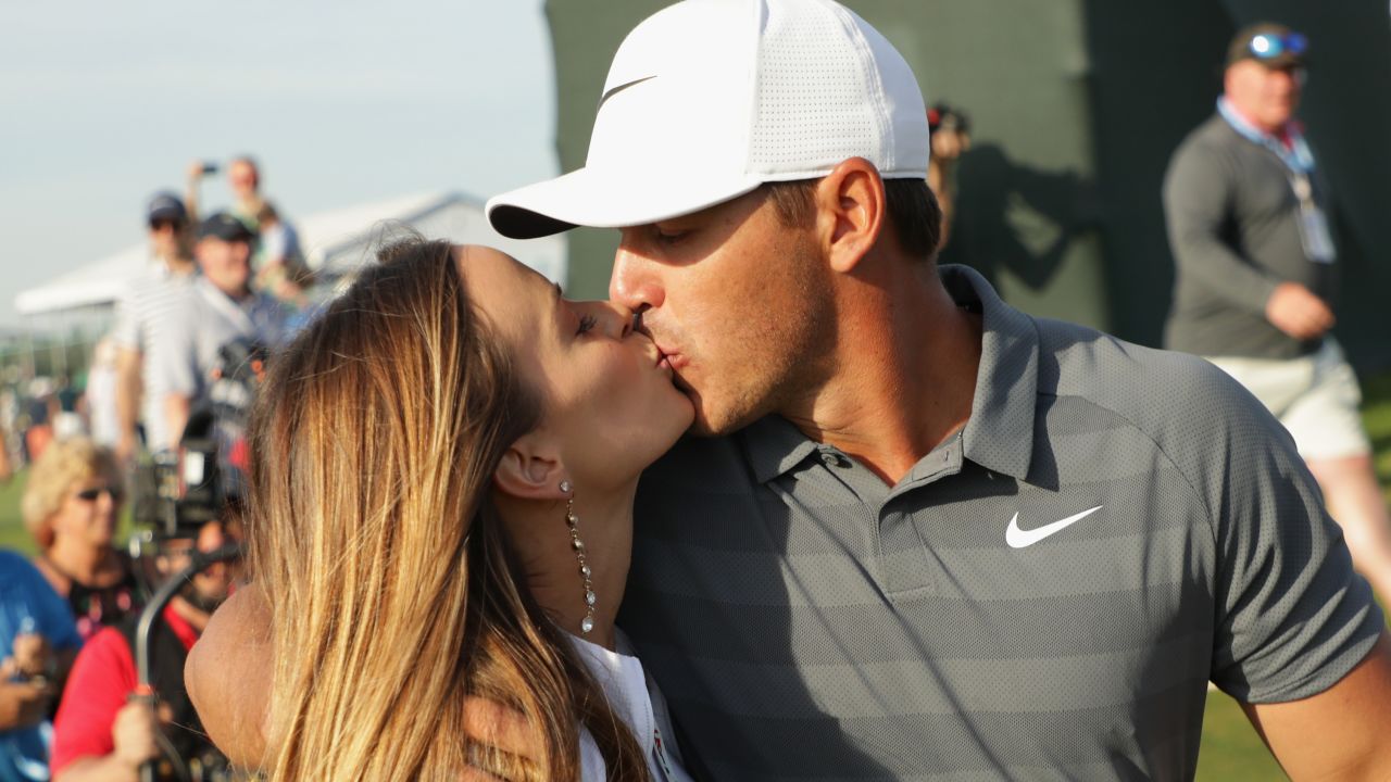 Brooks Koepka kisses girlfriend Jena Sims as he walks off the 18th at Shinneock Hills.