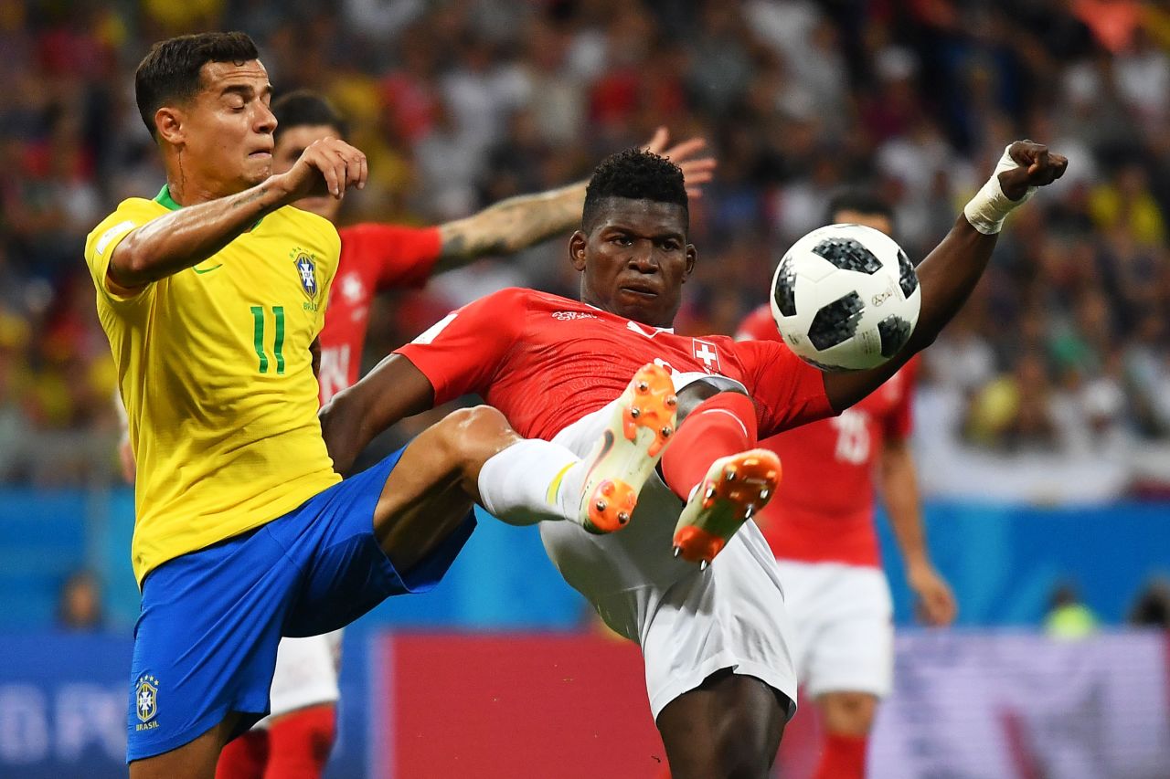 Brazil's Philippe Coutinho and Switzerland's Breel Embolo compete for the ball.
