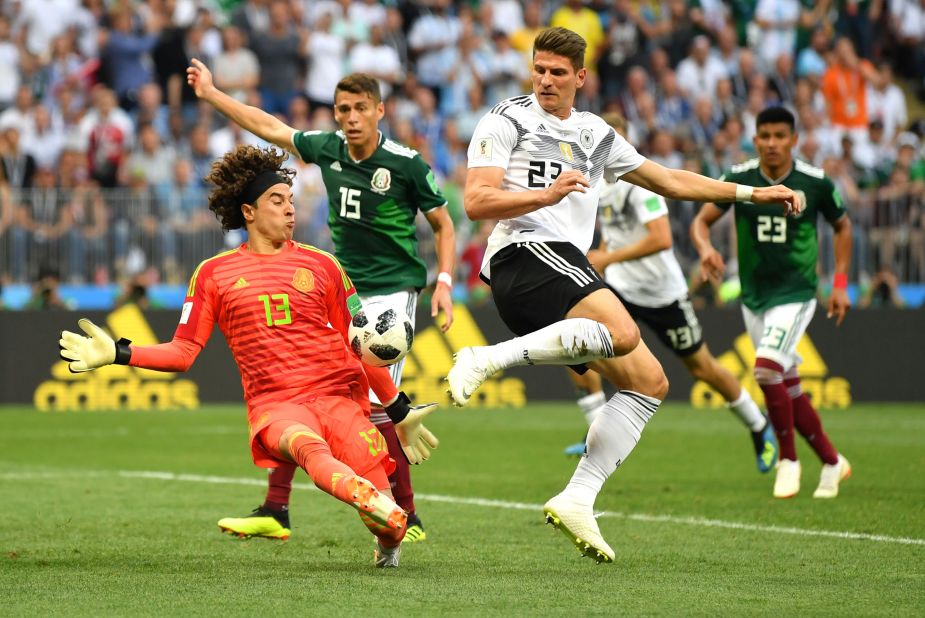 Mexican goalkeeper Guillermo Ochoa makes a late save against Mario Gomez.