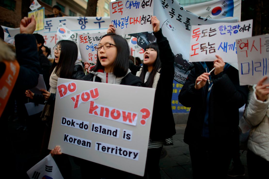 Demonstrators hold placards and shout slogans during a protest over the disputed Dokdo/Takeshima islands in front of the Japanese Embassy in Seoul on February 22, 2014.