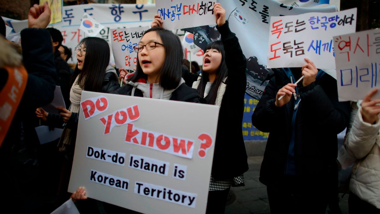 Demonstrators hold placards and shout slogans during a protest over the disputed Dokdo/Takeshima islands in front of the Japanese Embassy in Seoul on February 22, 2014.