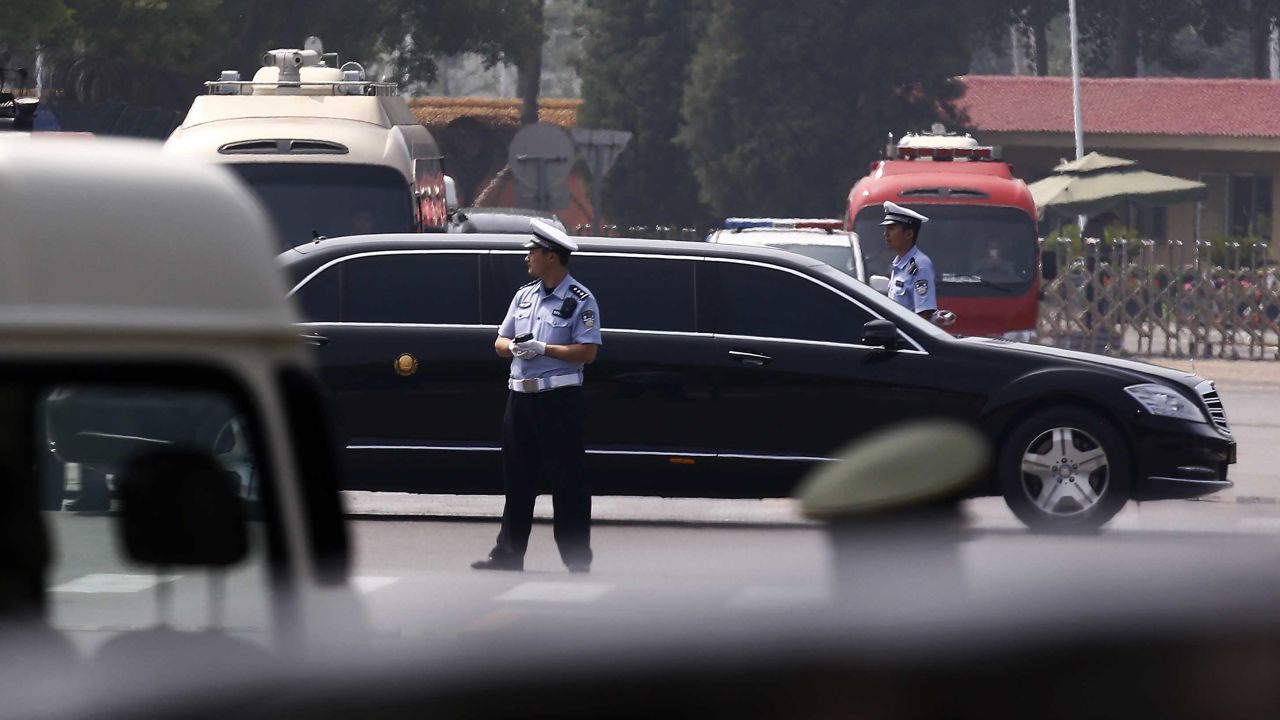 The motorcade in which Kim is believed to be traveling passes by policemen as it leaves the Beijing Capital International Airport.
