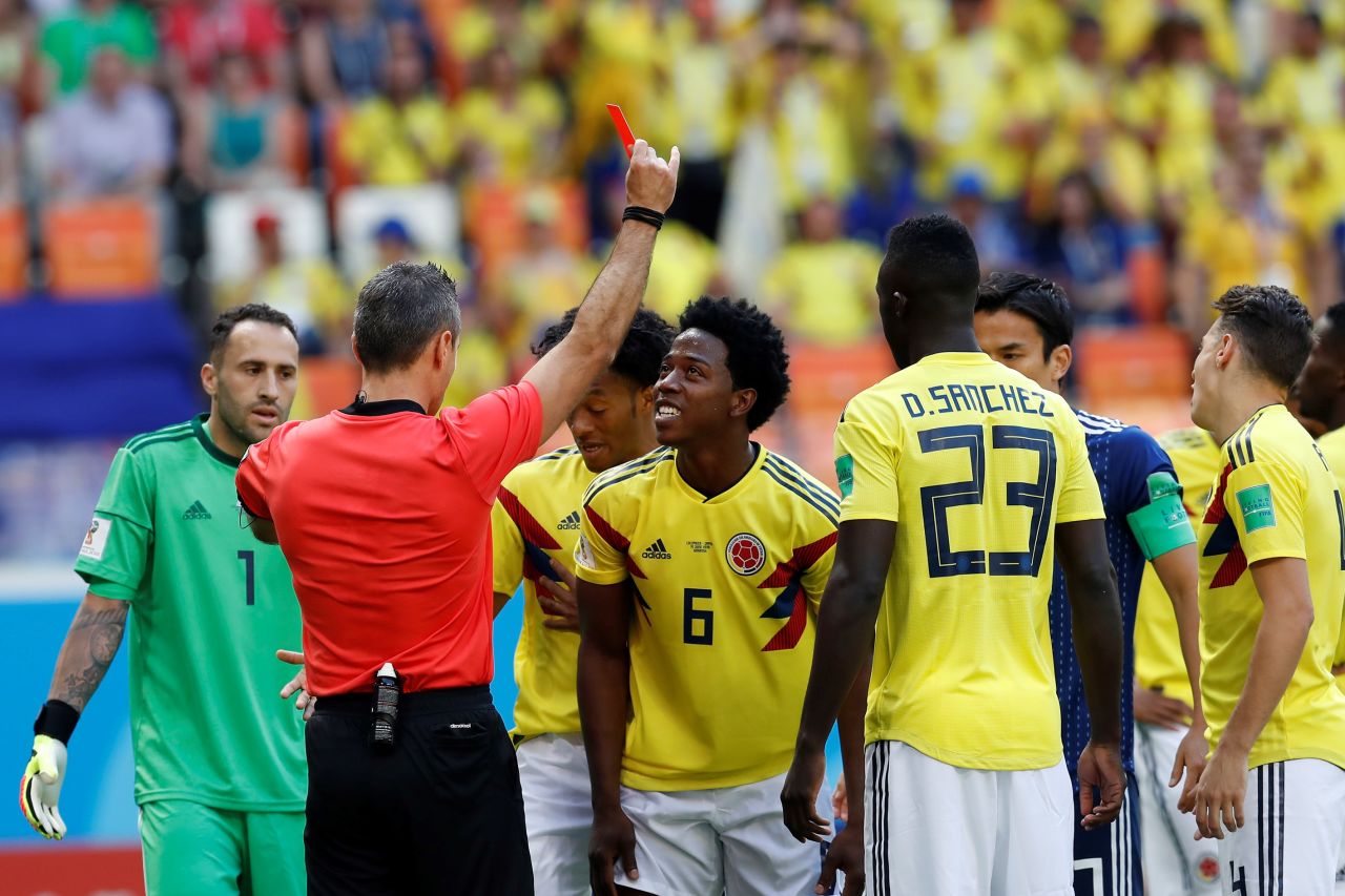 The referee shows a red card to Colombia's Carlos Sanchez in the third minute. Sanchez was deemed to have deliberately handled the ball in the box.