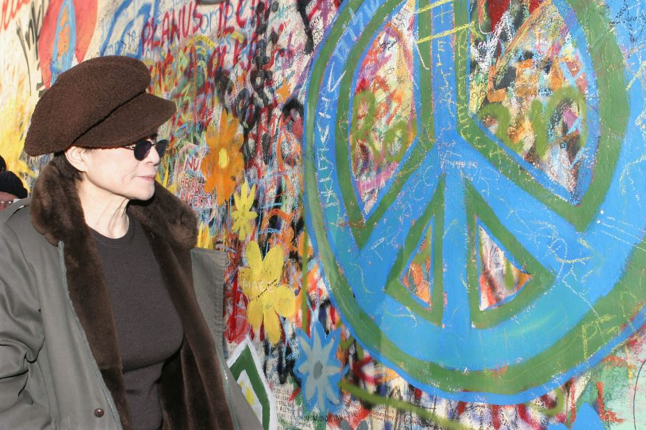Yoko Ono looks at a peace symbol on the John Lennon Peace Wall in Prague, Czech Republic in 2003.