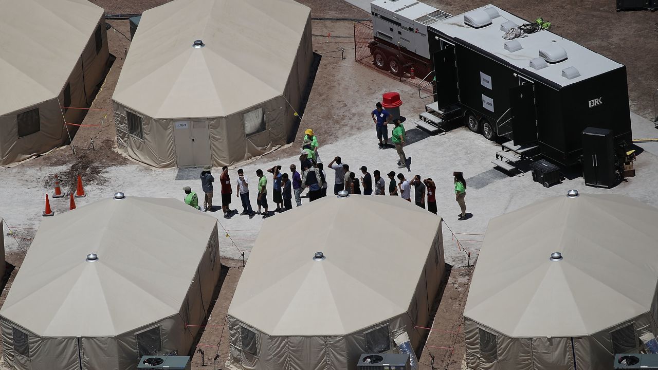 Unaccompanied migrant children stand in a line.