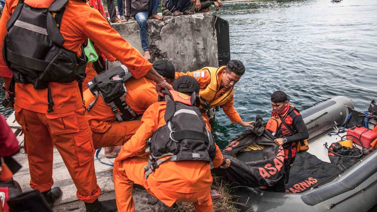 Rescue team members prepare to search for missing passengers at the Lake Toba ferry port in the province of North Sumatra on June 20, 2018.