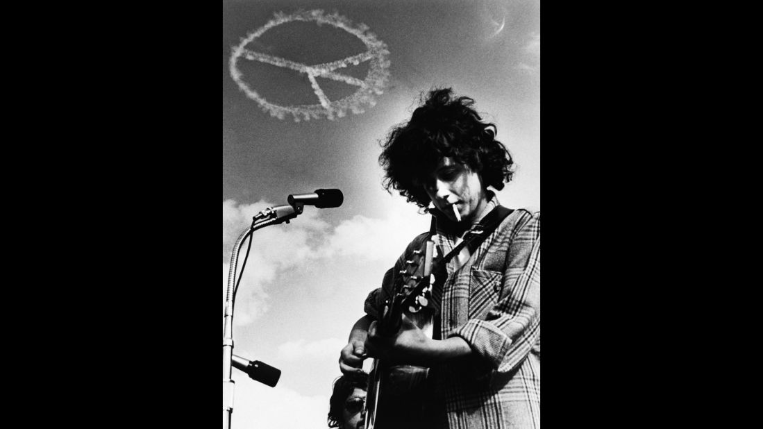 Folk singer Arlo Guthrie performs at a 1969 music festival in Medford, Massachusetts, as a skywriting pilot makes a peace symbol in the sky. 