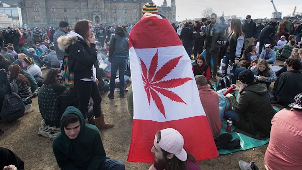 A man wears a Canadian flag on which a marijuana leaf has replaced the maple leaf during a rally on Parliament Hill in Ottawa in April.