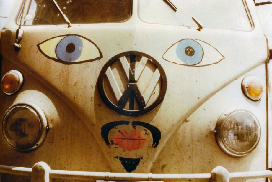 A logo on a Volkswagen bus converted to a peace symbol in a photograph by Ken Kolsbun.