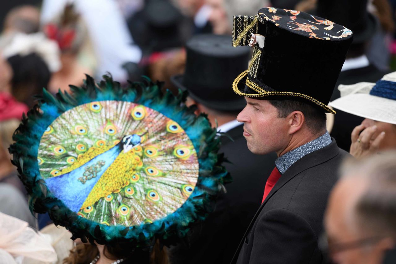 Two racegoers wear ornately decorated hats during Royal Ascot.